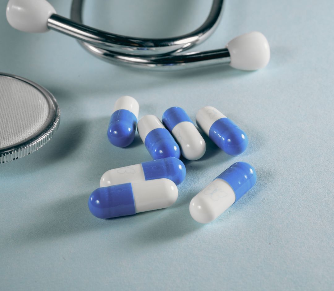 a collection of pills next to a stethoscope